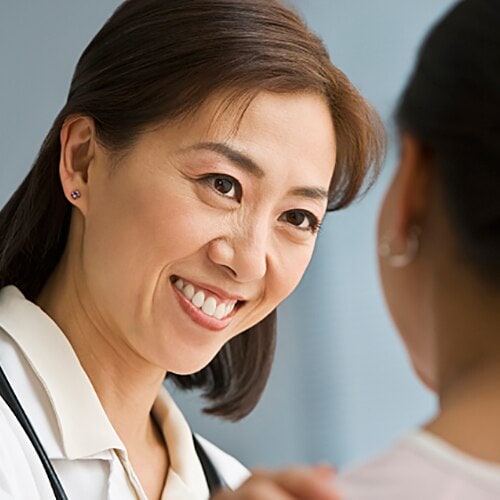 Female doctor with short hair smiling directly at a patient